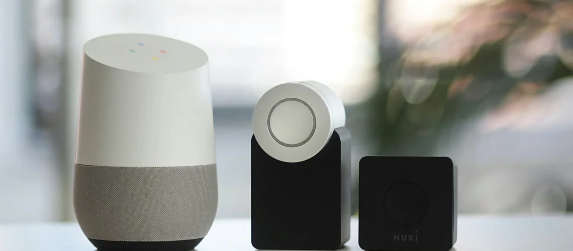 white and gray Google smart speaker and wo black speakers